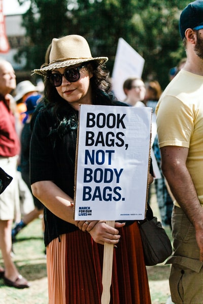 女人拿着书包，不是尸袋。招牌